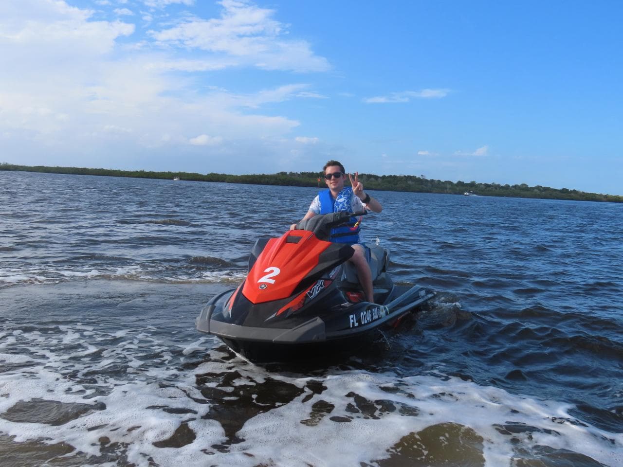 A rider throwing a peace sign while cruising the wide open estuary.